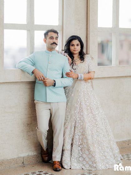 A stylish and confident pose from an indoor pre-wedding shoot. The groom's relaxed lean and the bride's elegant posture create a portrait that is both modern and timeless.