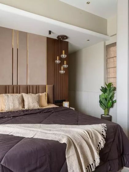 This elegant bedroom showcases a perfect harmony of modern luxury and timeless charm. The textured headboard with gold accents adds a refined touch, while the neutral palette is enriched by layered fabrics and soft lighting.