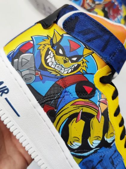 A hand-held shot showing the vibrant colors and clean line work on the SWAT Kats Nike Air Force 1s. This is pure nostalgia in the form of wearable art.