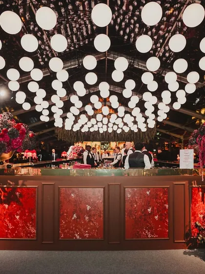 The grand, flower-laden bar at a red-themed cocktail night. The bar is often a central feature, and we make sure it's a showstopper.