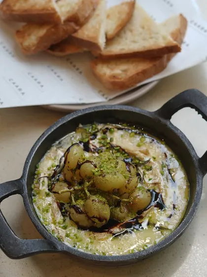 Our oven-roasted Kumaoni grapes on melted hot brie, ready to be served. This dish highlights our commitment to using exceptional regional ingredients in creative ways.