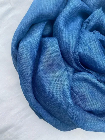 A close-up of the Kota silk stole, showing the rich texture and deep blue of the natural indigo dye.