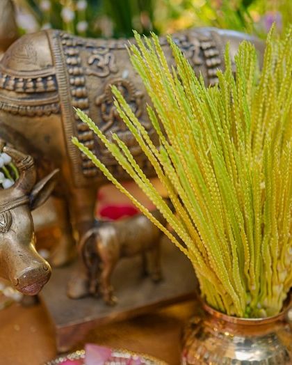 A close-up of a brass cow and calf statue, a symbol of prosperity and nurturing, adorned with a small flower garland. It's these thoughtful, symbolic touches that enrich the wedding decor.