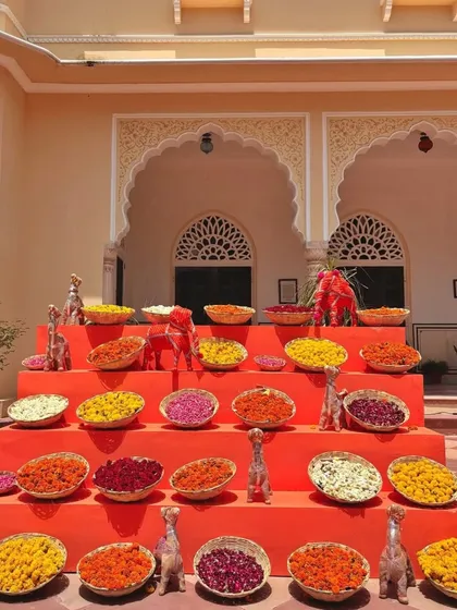 A vibrant display of flower petals in various colors. Arranged in tiers, this setup is both a beautiful decor element and a station for guests to shower the couple with blessings.