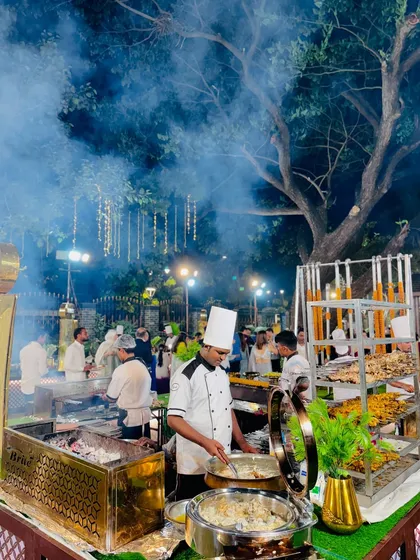 The barbecue station set against a backdrop of trees and lights, creating a magical ambiance for an evening of delicious grilled food.