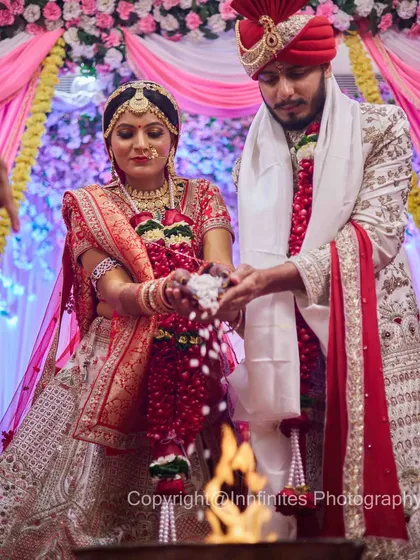 The sacred fire (Agni) is central to the Hindu wedding. This shot captures the couple performing the ritual together, with the warm glow of the fire illuminating their traditional attire.