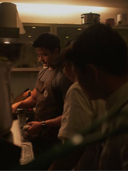 A behind-the-scenes shot of my team working in a dimly lit kitchen, focused on their tasks.