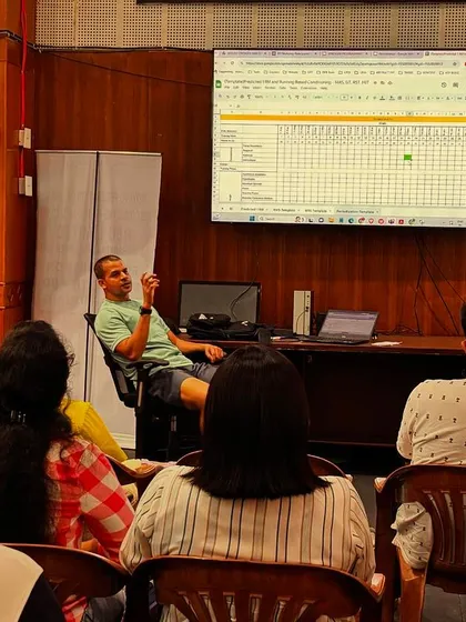 Explaining a periodization plan on screen during a workshop for boxing coaches. We look at how to structure training blocks based on data to ensure athletes peak at the right time.