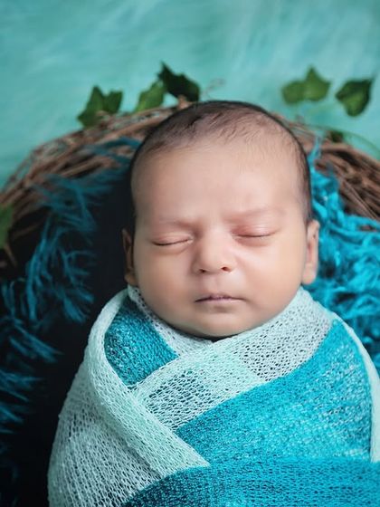 A close-up portrait of a sleeping newborn in a nest prop. This angle allows you to see their peaceful expression and the delicate details of their face.