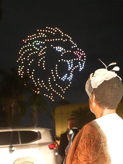 A guest watches in awe as our drones form a roaring lion's head in the sky above Zimbabwe. This powerful image was part of our spectacular New Year's celebration in Africa.