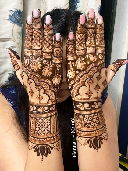 A lovely design with a central floral motif and delicate net patterns on the fingers.