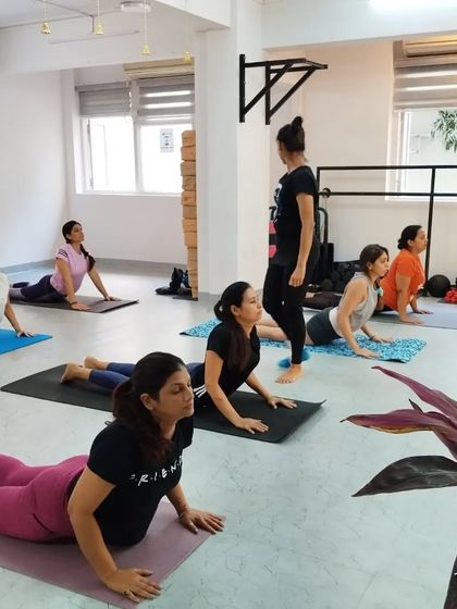 Students practice Bhujangasana (Cobra Pose), a gentle backbend that strengthens the spine and opens the chest.