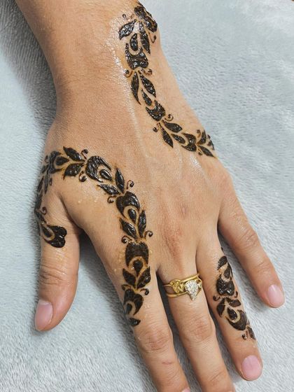 A delicate vine pattern that swirls gracefully across the back of the hand and fingers.