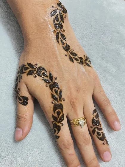A delicate vine pattern that swirls gracefully across the back of the hand and fingers.