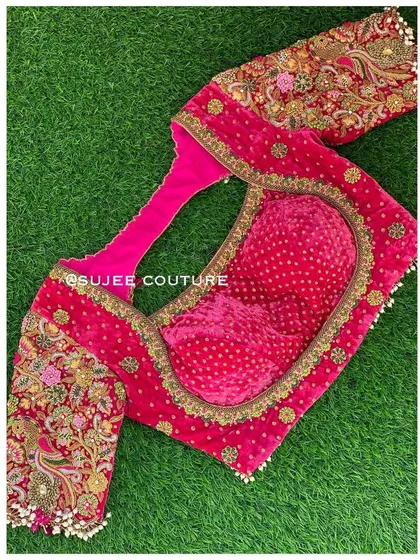 The front view of the pink velvet blouse, showing the sweetheart neckline and the heavily embroidered sleeves. The inside features a contrasting bandhani print lining for a hidden detail.
