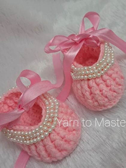These pink booties are a classic ballerina style, with a string of pearls and a long pink ribbon to tie around the ankle.