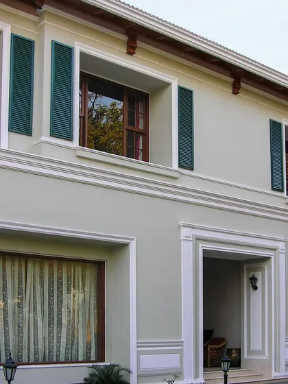 Inspired by London townhouses, this facade uses classic details like decorative shutters and pronounced window moldings to create a sense of rhythm and timeless elegance.