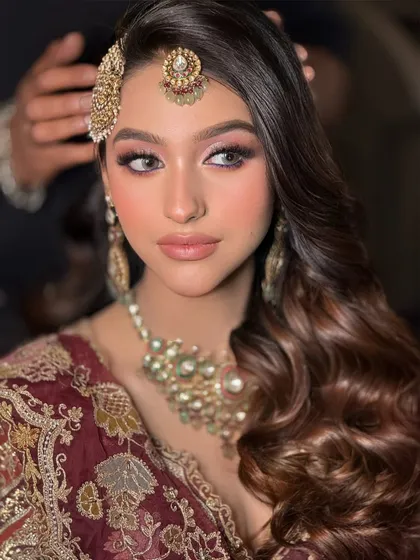 A close-up of this bride's soft glam makeup. The focus is on the beautifully blended eyeshadow, rosy cheeks, and a perfect nude lip.