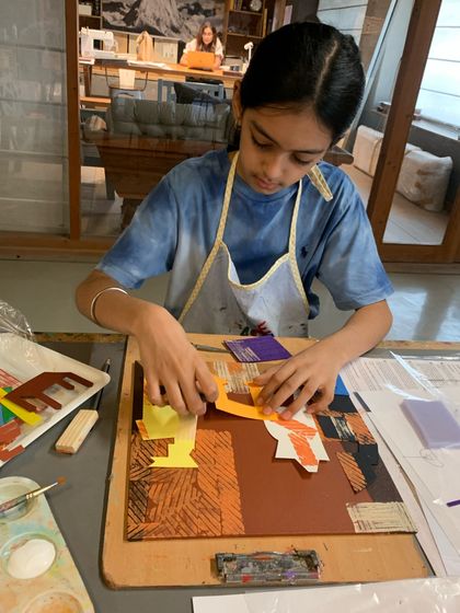 This student is in the process of creating her Picasso-inspired artwork, experimenting with the placement of different colored shapes.