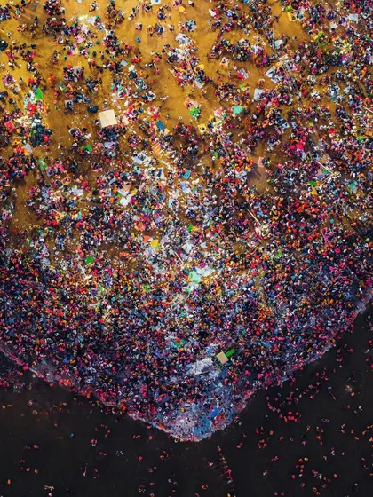 This is an abstract aerial photograph of the crowd at the Mahakumbh Mela. From this height, the mass of people becomes a canvas of color and texture, representing a single collective energy.