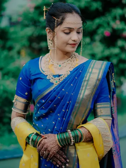 A close-up of the bride, showcasing her traditional Maharashtrian jewelry, including the mundavalya and elaborate necklace.