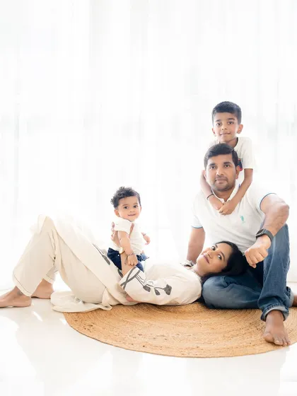 A playful pose with the kids climbing on their parents. This captures the fun and energy of family life, resulting in a genuine and happy memory.