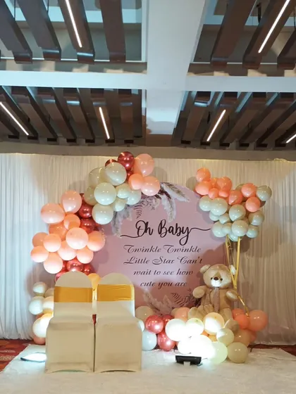 Welcoming a new arrival with a beautiful and serene "Oh Baby" themed baby shower. This setup features a soft color palette of rose gold and white balloons, a personalized backdrop, and a cozy seating area for the parents-to-be.