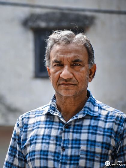A simple, straightforward portrait of a man I met. The checkered shirt and the neutral background keep the focus entirely on his face and his calm demeanor.