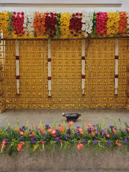 A detailed shot of the golden panel backdrop, showing the rows of bells and hanging jasmine garlands.