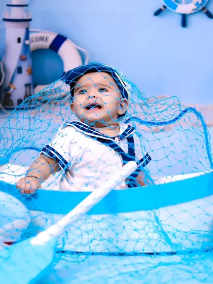 A funny, candid moment as the baby gets tangled in a fishing net during the sailor shoot.