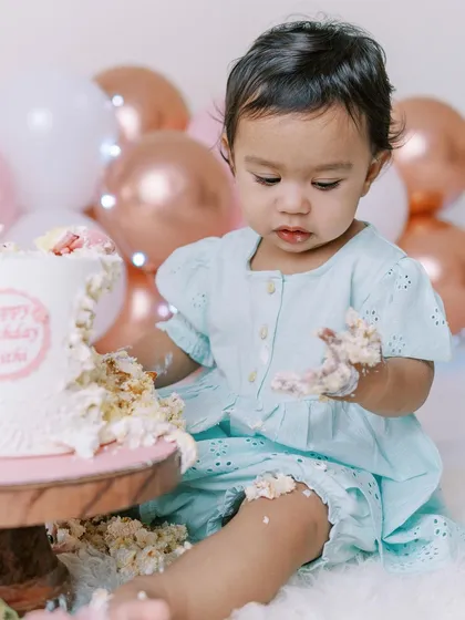 Getting hands-on with the cake. I love capturing each baby's unique reaction to their first taste of birthday cake during our at-home sessions.