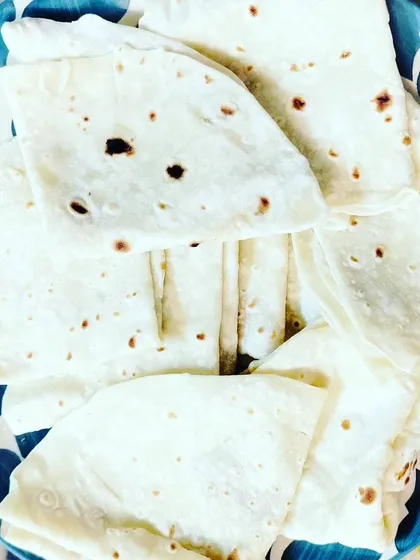 A plate of soft, folded phulkas or rumali rotis. We make our breads fresh for every order, ensuring they are warm and perfect for scooping up our delicious curries.