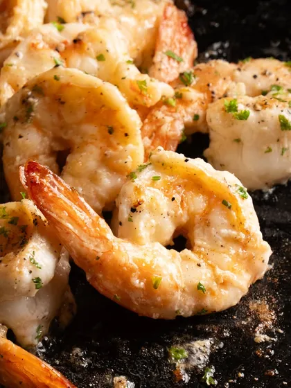 A macro shot of the butter garlic prawns, focusing on the glistening sauce and herbs.