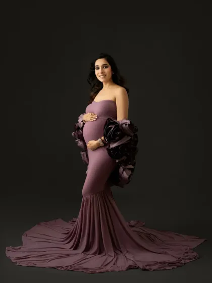 A direct, smiling portrait that radiates joy. Even in a high fashion gown, your personality can shine through. This is a perfect example of a glamorous yet warm maternity photo.