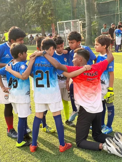 A coach shares a special moment with his young team, building the trust and bonds that define our academy culture.