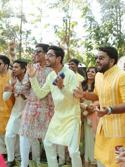 The groom's friends and family dancing with abandon during the Haldi celebrations. I ensure the music and atmosphere are perfect for creating these moments of pure fun.