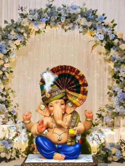 A beautiful floral arch in soft blue and white hues provides a serene and calming frame for the Ganpati idol. This unique color choice is perfect for a modern and peaceful celebration.