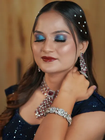 A stunning cocktail look with a bold blue smokey eye and a deep red lip, perfect for making a statement.