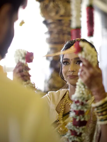 The exchange of garlands during a South Indian wedding, a symbol of acceptance and unity. We focus on the expressions and the ritual's significance.