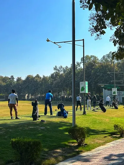 A clear, sunny day on the range with a group of golfers enjoying the perfect weather.