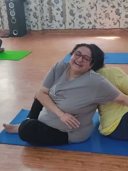 Partner yoga is a wonderful way to relax and deepen your practice. Here, two clients enjoy a supported spinal twist, using each other for stability and gentle resistance to release tension in the back and shoulders.