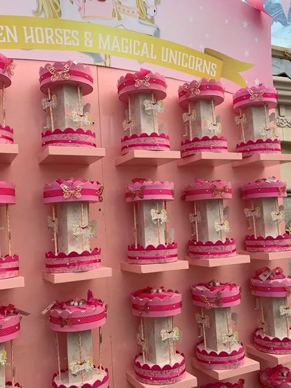 A closer look at the wall of 'Golden Horses & Magical Unicorns' party favors. The consistent pink and white color scheme and delicate details created a stunning visual display.