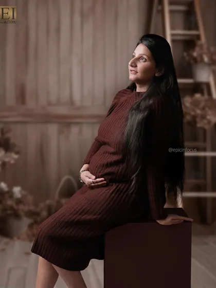 A hopeful, upward glance in a modern knit dress, set against a rustic wooden studio background.