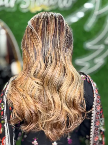 Adding color adds confidence. This multi-tonal blonde and brown highlight look is styled with soft waves to show off the flawless blend.