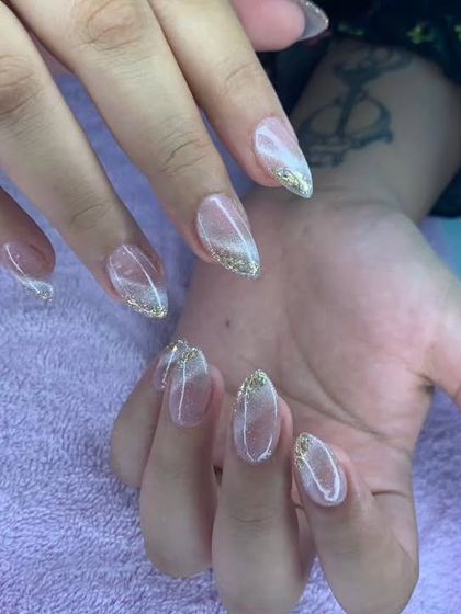 A sheer, shimmery base with a gold glitter fade at the tips. Simple, elegant, and sparkly.