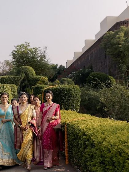 The bride's 'baraat' or procession, as she walks towards the mandap with her bridesmaids. This image celebrates the joy and support of friends and family leading up to the ceremony.