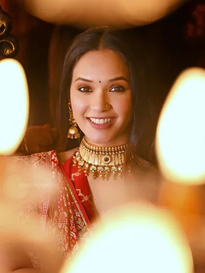 A warm and inviting portrait of a woman in traditional attire, framed by the soft glow of candles.