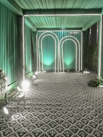 An interior view of the modern teal entrance tunnel, showing the repeating illuminated arches that create a futuristic and visually engaging path for guests.