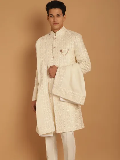 Presenting your Royal Highness. This traditional Rajwara-style sherwani in ivory features tone-on-tone embroidery, offering a light and summery look for your wedding day. With over 50 color options, we can create the perfect twining look with your bride.