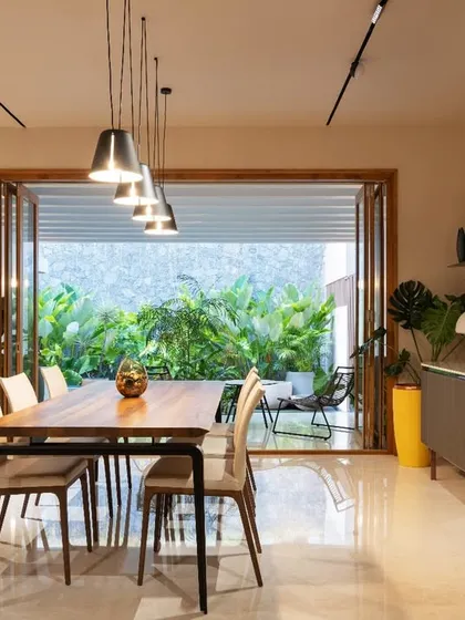 A repeat view of the dining room opening to the garden, emphasizing the indoor-outdoor living concept that is central to our terratropical design style.